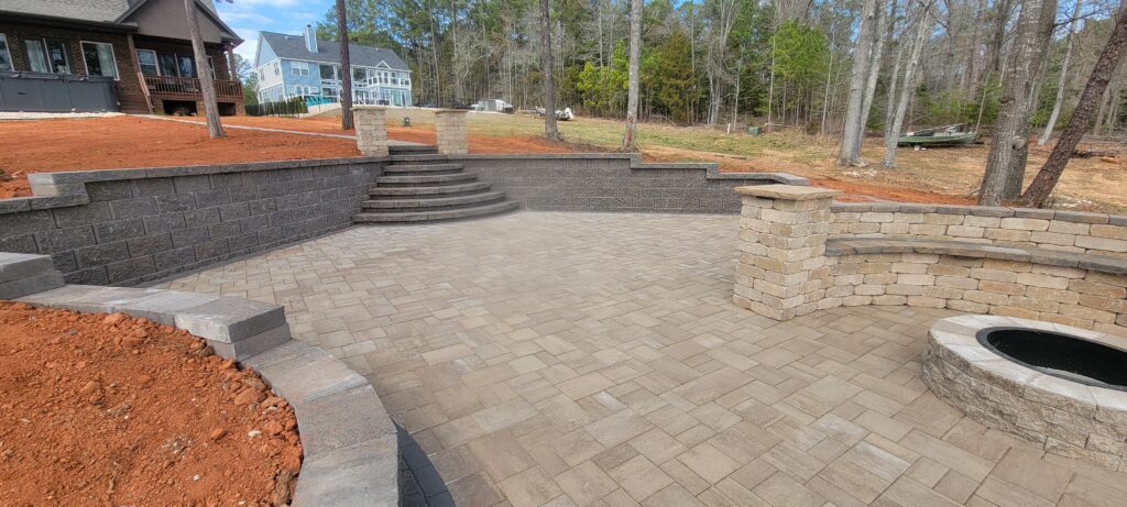 Paver patio with curved steps and a block seating wall