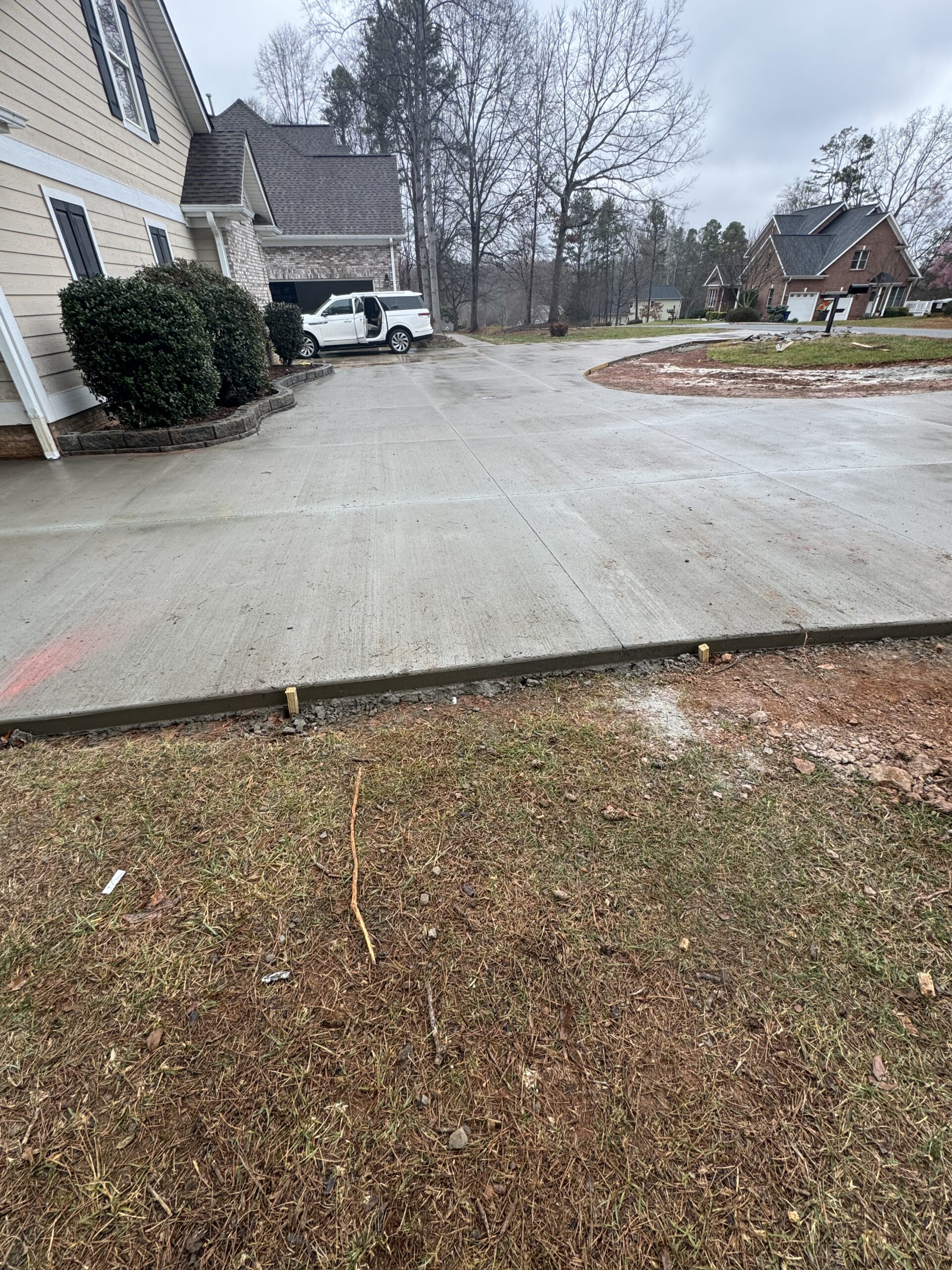 Concrete driveway and parking area beside a house