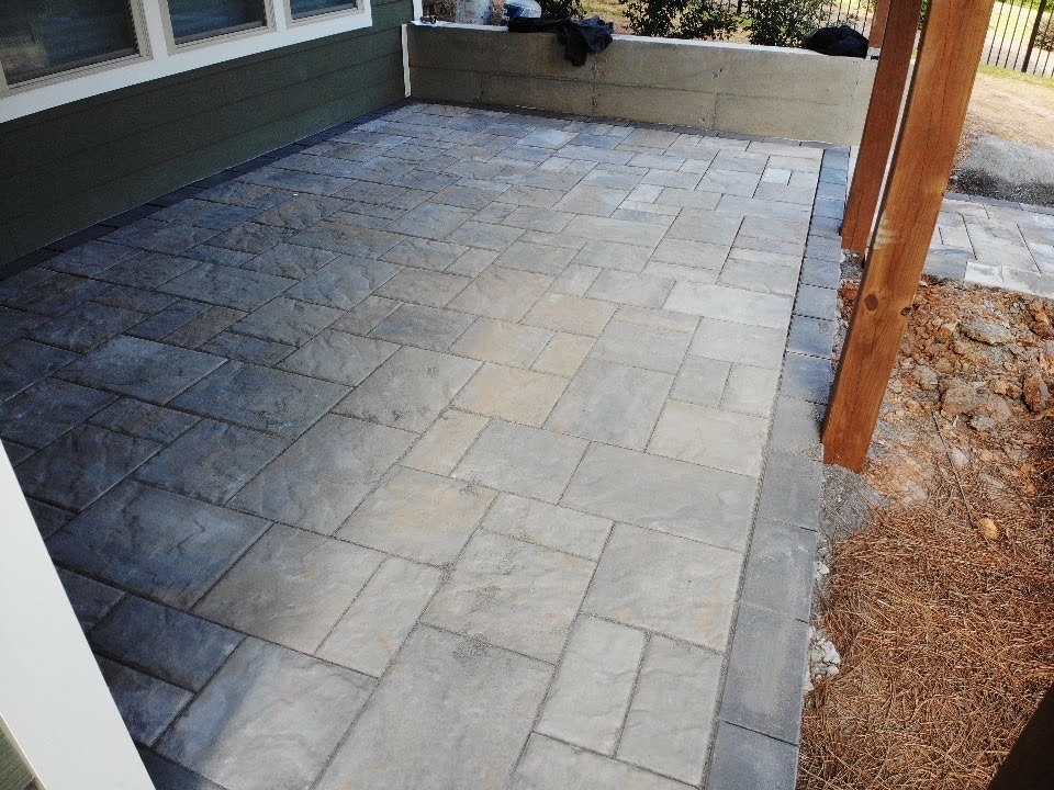 Gray paver patio beneath a covered outdoor area