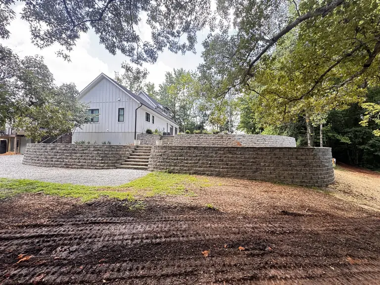 Block retaining wall beside a house and graded yard